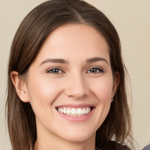 Joyful white young-adult female with medium  brown hair and grey eyes