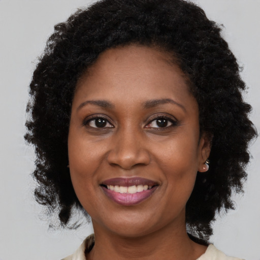 Joyful black adult female with medium  brown hair and brown eyes