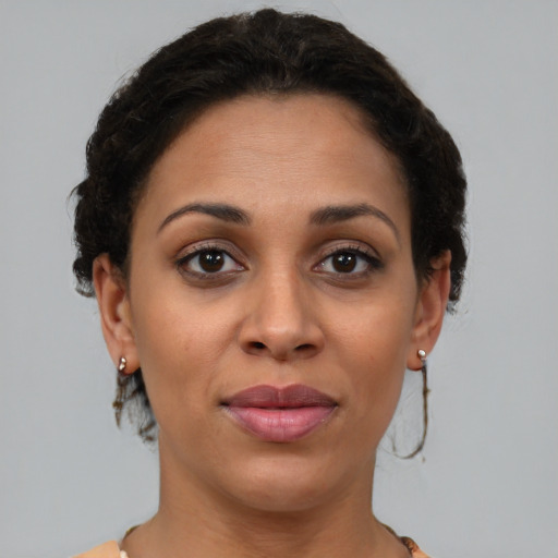 Joyful black adult female with short  brown hair and brown eyes