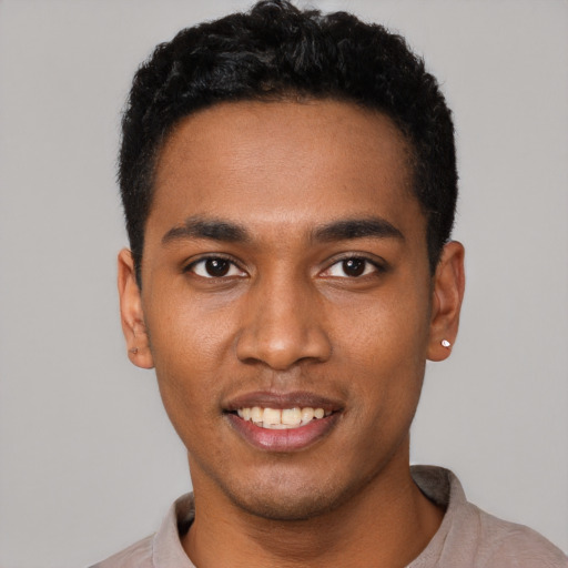 Joyful black young-adult male with short  black hair and brown eyes