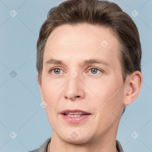 Joyful white adult male with short  brown hair and grey eyes