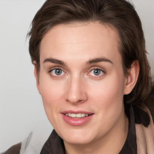 Joyful white young-adult female with long  brown hair and grey eyes