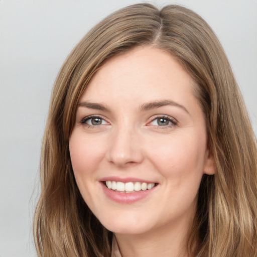 Joyful white young-adult female with long  brown hair and green eyes