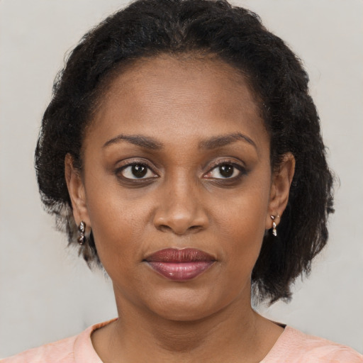 Joyful black adult female with medium  brown hair and brown eyes