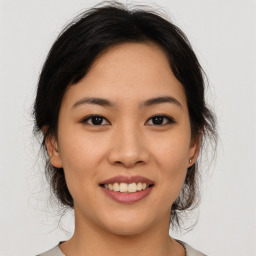 Joyful asian young-adult female with medium  brown hair and brown eyes