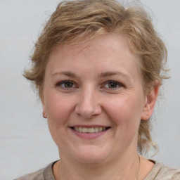 Joyful white young-adult female with medium  brown hair and blue eyes