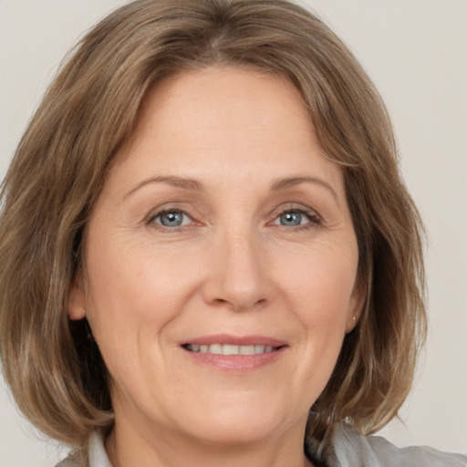 Joyful white adult female with medium  brown hair and grey eyes