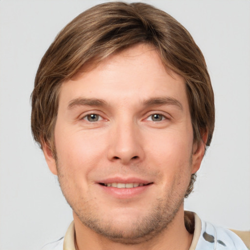 Joyful white young-adult male with short  brown hair and grey eyes