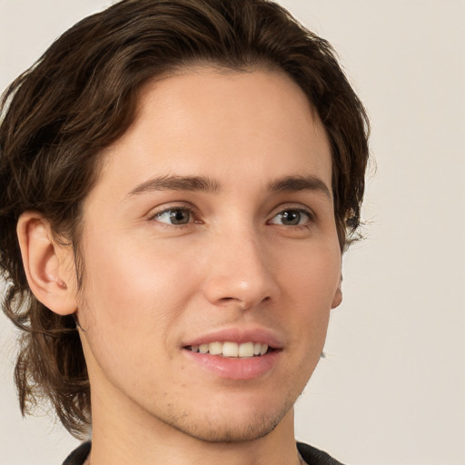 Joyful white young-adult male with medium  brown hair and grey eyes