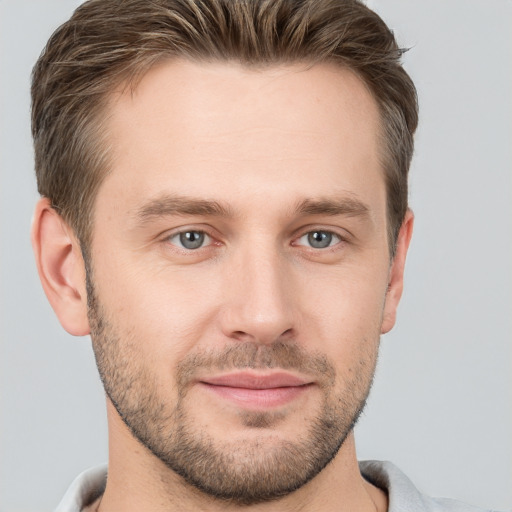 Joyful white young-adult male with short  brown hair and grey eyes