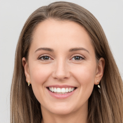 Joyful white young-adult female with long  brown hair and grey eyes