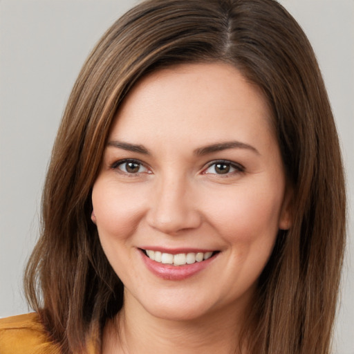 Joyful white young-adult female with long  brown hair and brown eyes