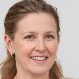 Joyful white adult female with long  brown hair and grey eyes