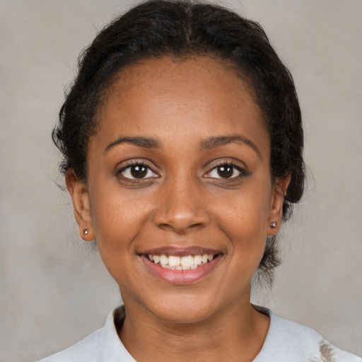 Joyful black young-adult female with medium  brown hair and brown eyes