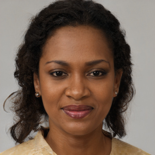 Joyful black adult female with medium  brown hair and brown eyes