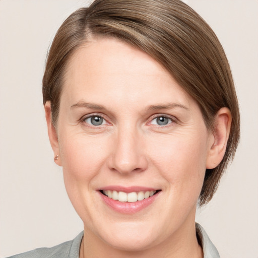 Joyful white adult female with medium  brown hair and grey eyes