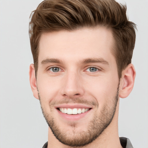 Joyful white young-adult male with short  brown hair and grey eyes