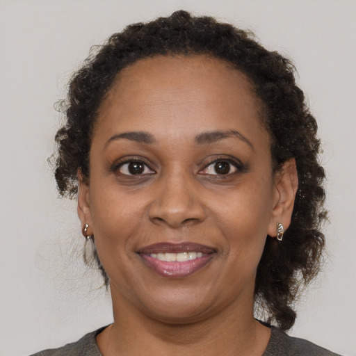 Joyful black adult female with medium  brown hair and brown eyes