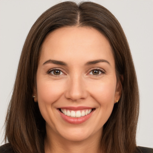 Joyful white young-adult female with long  brown hair and brown eyes