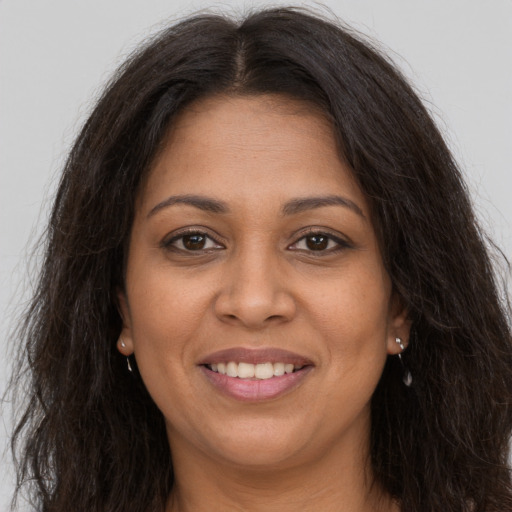 Joyful black adult female with long  brown hair and brown eyes