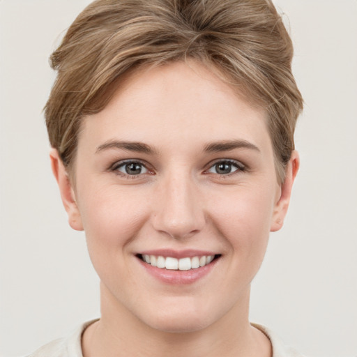 Joyful white young-adult female with short  brown hair and grey eyes