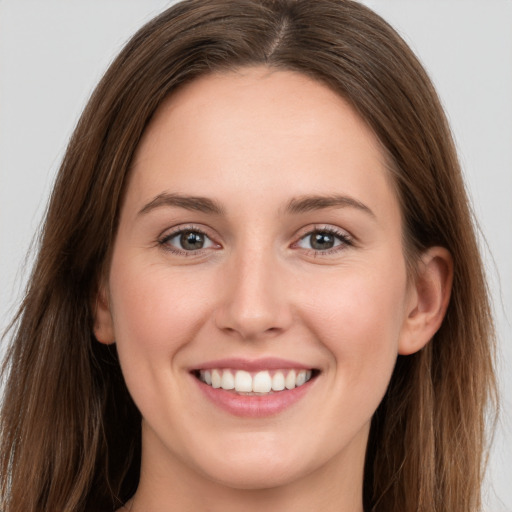 Joyful white young-adult female with long  brown hair and grey eyes