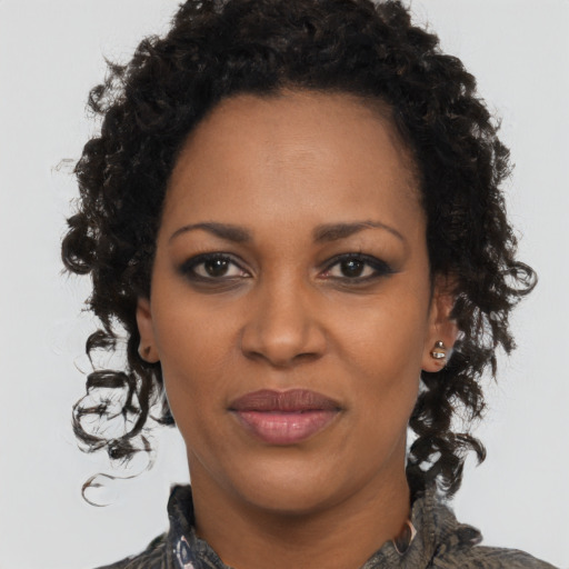 Joyful black young-adult female with long  brown hair and brown eyes