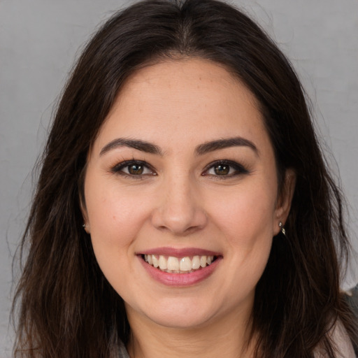 Joyful white young-adult female with long  brown hair and brown eyes