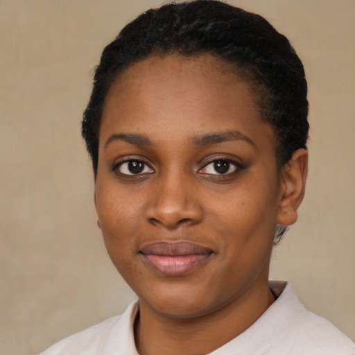 Joyful black young-adult female with short  black hair and brown eyes