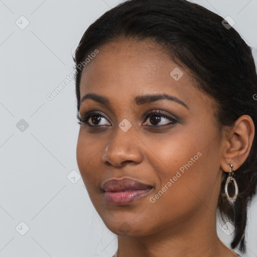 Joyful black young-adult female with long  black hair and brown eyes