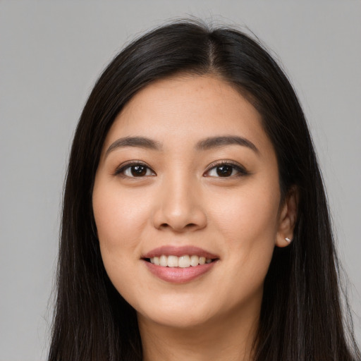 Joyful latino young-adult female with long  brown hair and brown eyes