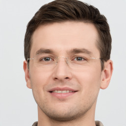 Joyful white young-adult male with short  brown hair and grey eyes