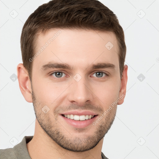 Joyful white young-adult male with short  brown hair and grey eyes