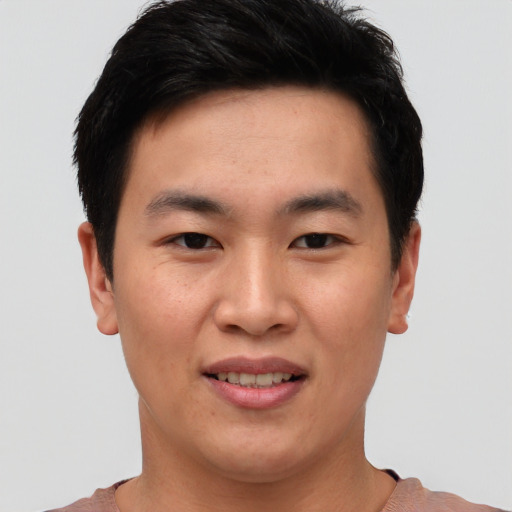 Joyful asian young-adult male with short  brown hair and brown eyes
