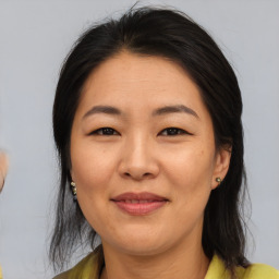 Joyful asian adult female with medium  brown hair and brown eyes