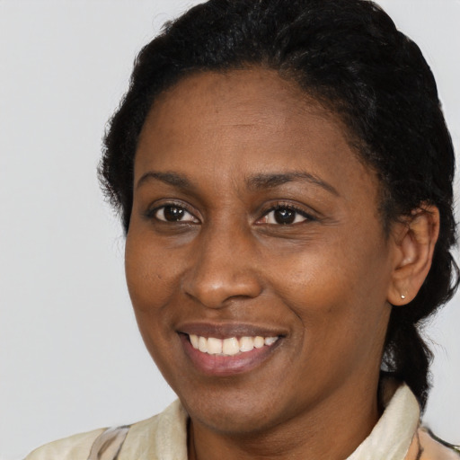 Joyful black adult female with long  brown hair and brown eyes
