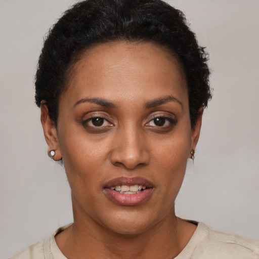 Joyful black young-adult female with short  black hair and brown eyes