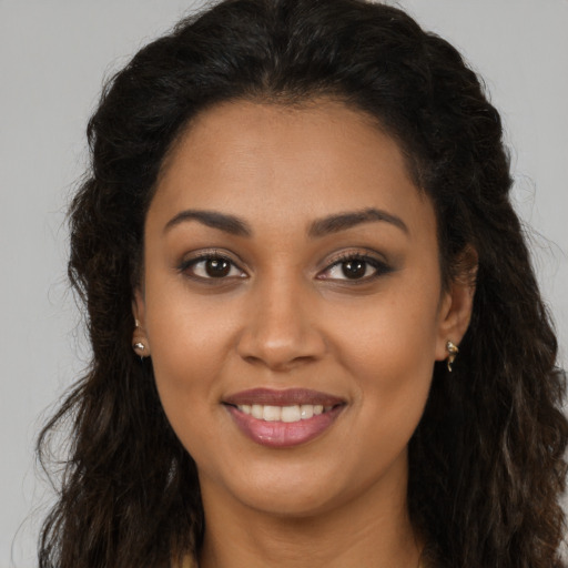 Joyful latino young-adult female with long  brown hair and brown eyes