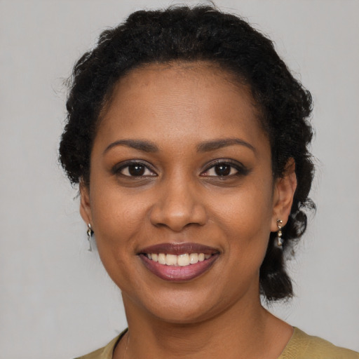 Joyful black young-adult female with short  brown hair and brown eyes