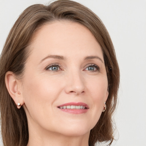 Joyful white adult female with long  brown hair and grey eyes