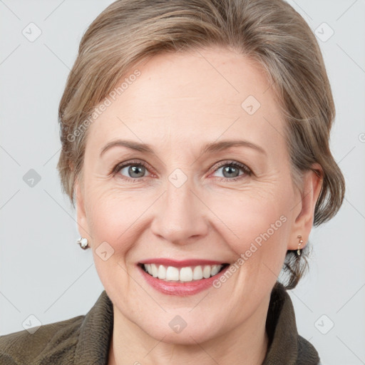 Joyful white adult female with medium  brown hair and grey eyes