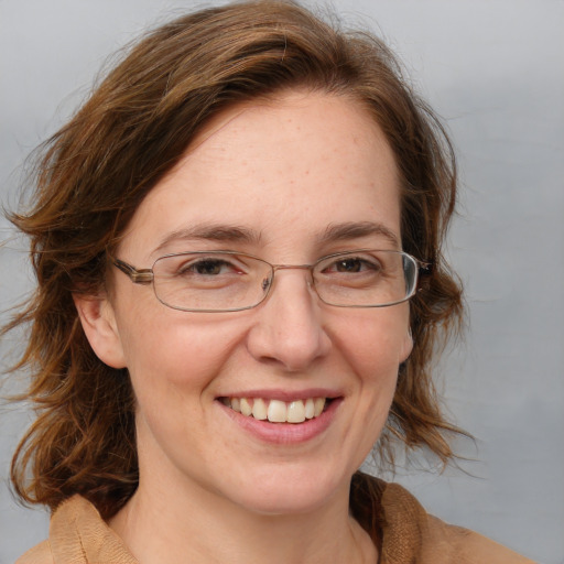 Joyful white adult female with medium  brown hair and blue eyes