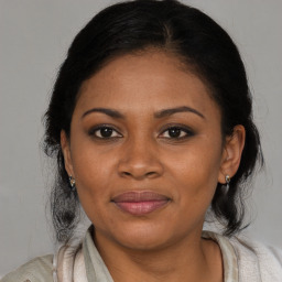 Joyful black adult female with medium  brown hair and brown eyes