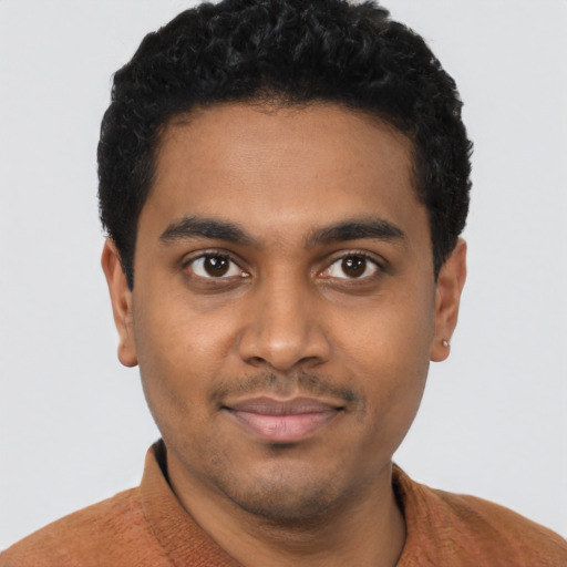 Joyful black young-adult male with short  black hair and brown eyes