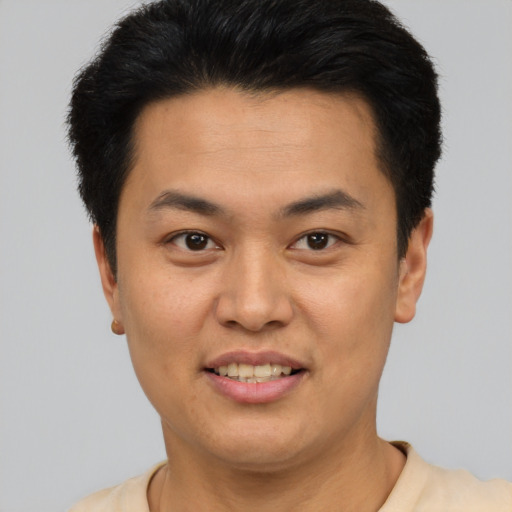 Joyful asian young-adult male with short  brown hair and brown eyes
