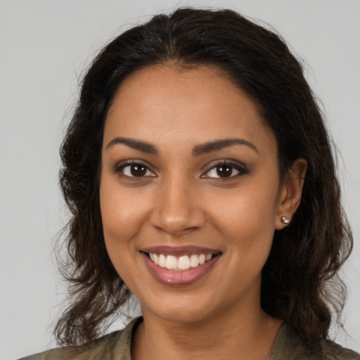 Joyful black young-adult female with long  brown hair and brown eyes