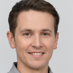 Joyful white adult male with short  brown hair and grey eyes