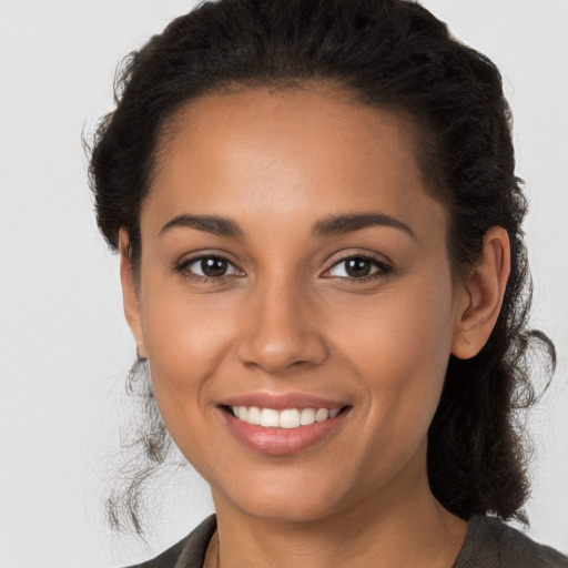 Joyful latino young-adult female with long  brown hair and brown eyes