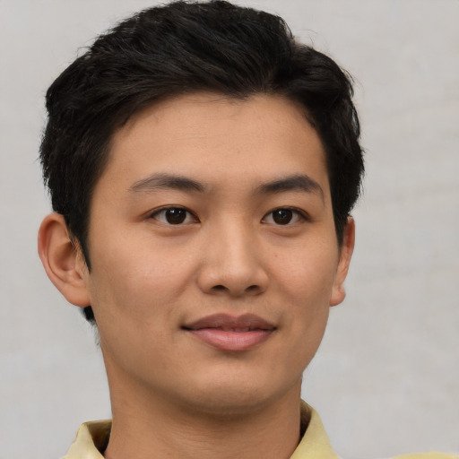 Joyful asian young-adult male with short  brown hair and brown eyes