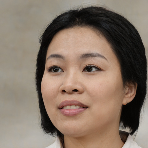 Joyful asian young-adult female with medium  black hair and brown eyes